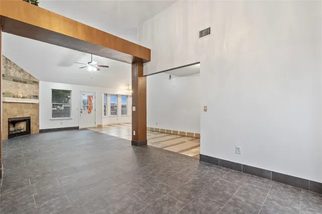 an empty room with fireplace and windows