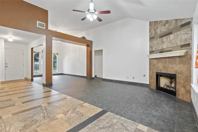 a view of empty room with fireplace and fan