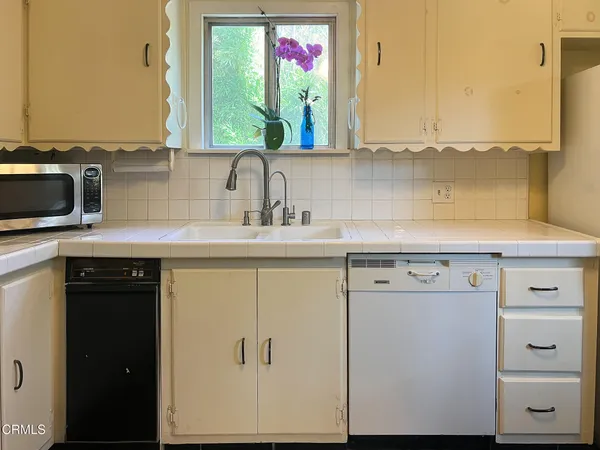 a kitchen with sink refrigerator and stove