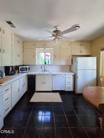a bathroom with a sink a window and a refrigerator