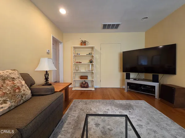 a bedroom with a bed and a flat tv screen on the dresser