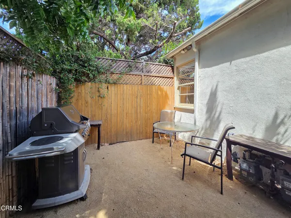a wooden bench sitting in backside of a house with wooden fence