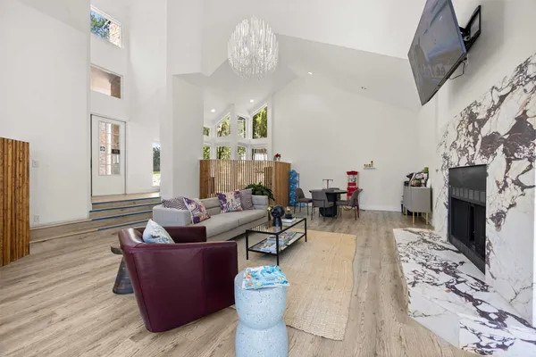 a living room with fireplace furniture and a chandelier