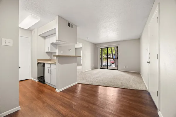 a view of a kitchen with wooden floor and a window