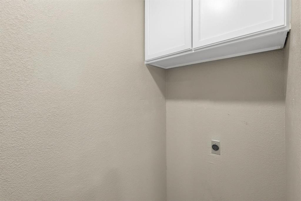 7733 Liz Lane Watauga, TX 76148 - Photo 14 of 27 Laundry area featuring cabinet space and electric dryer hookup