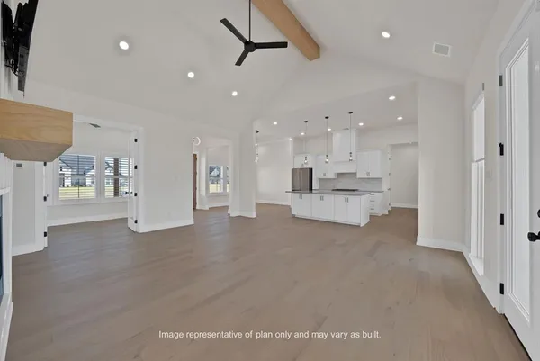 a view of an empty room and kitchen view