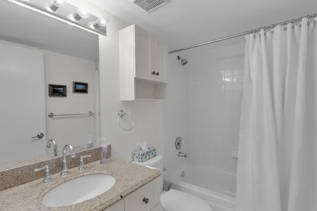 a bathroom with a granite countertop sink a mirror a shower and a bathtub