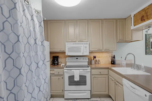 a kitchen with white cabinets and white appliances