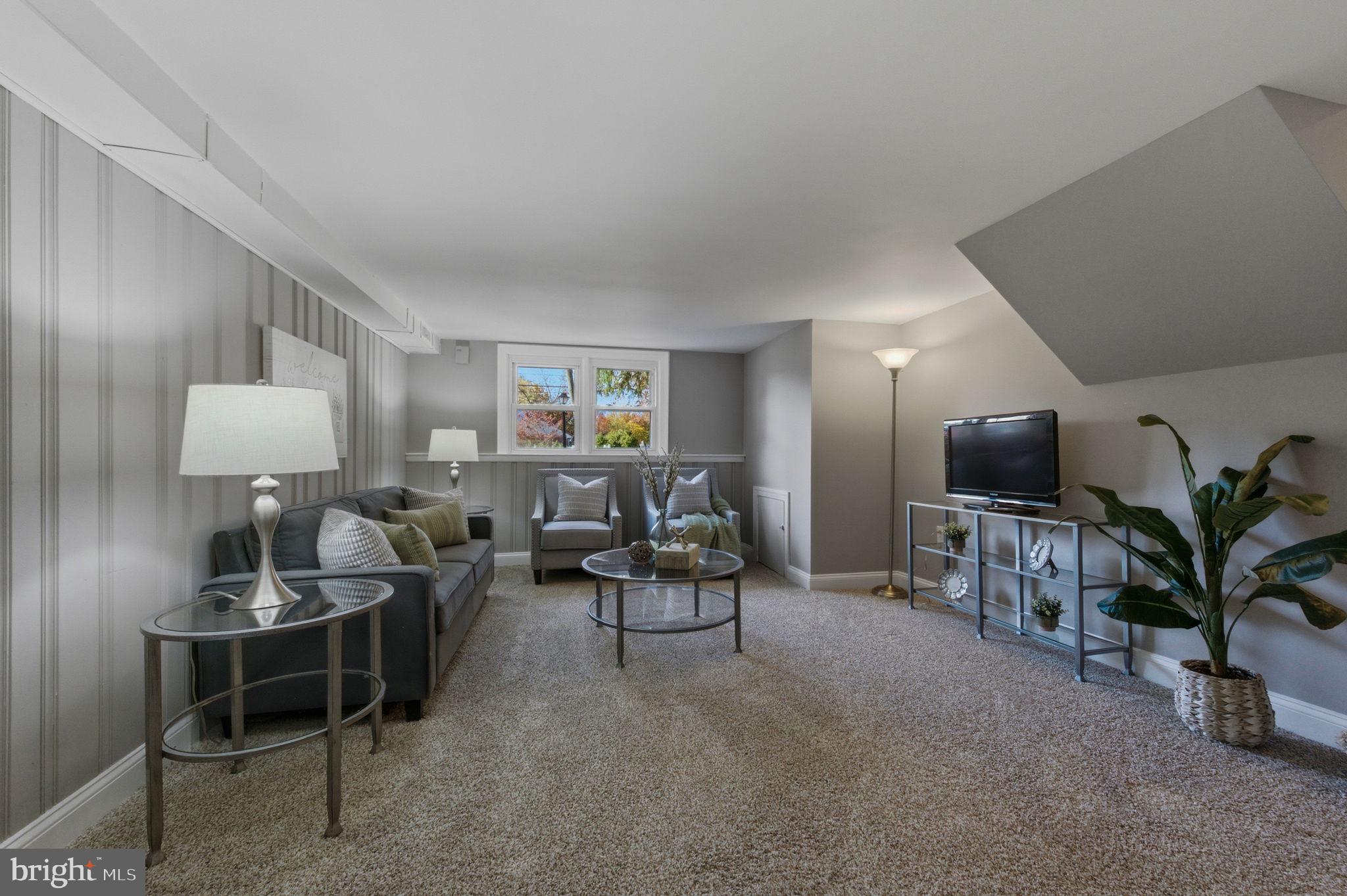 2247 Silverside Road Wilmington, DE 19810 - Photo 32 of 35 a living room with furniture a lamp and a potted plant
