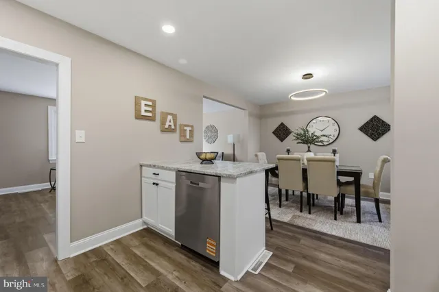 a kitchen with a table chairs sink and cabinets