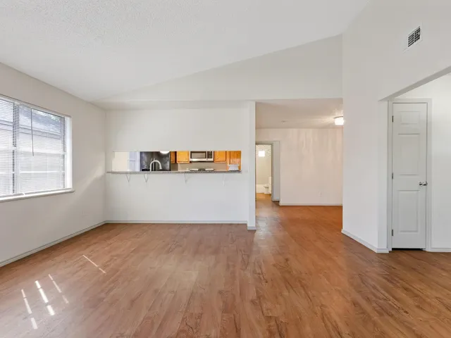 a view of a room with wooden floor and window