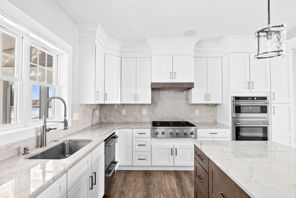 8 Beacon Street, Unit 80 Onset, MA 02558 - Photo 2 of 16 a kitchen with granite countertop a sink stainless steel appliances and white cabinets
