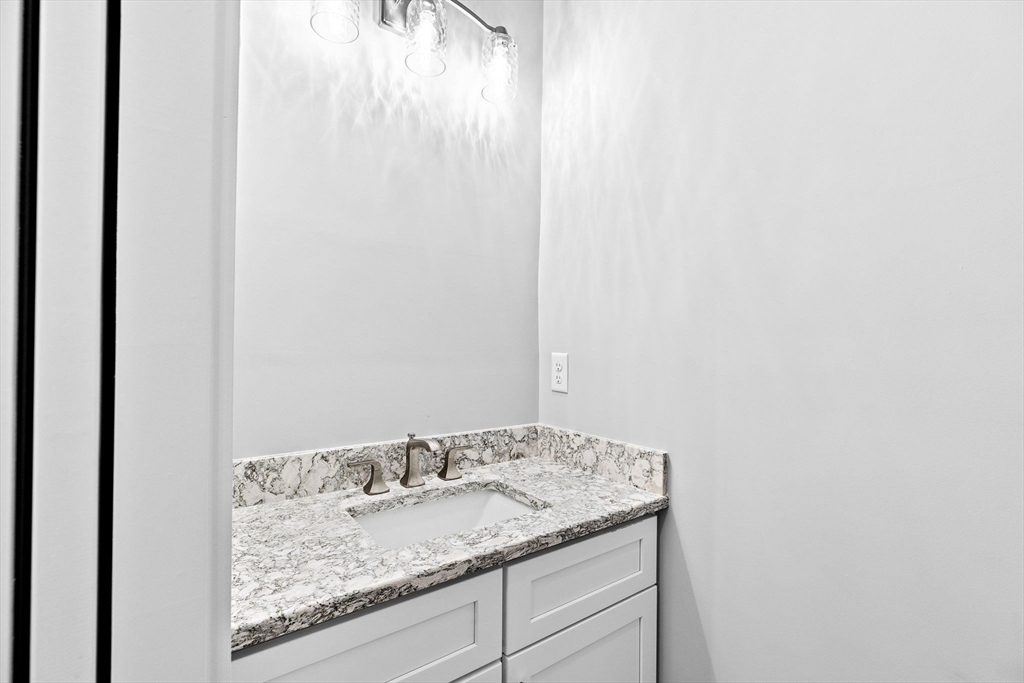 8 Beacon Street, Unit 80 Onset, MA 02558 - Photo 7 of 16 a bathroom with a granite countertop sink and vanity