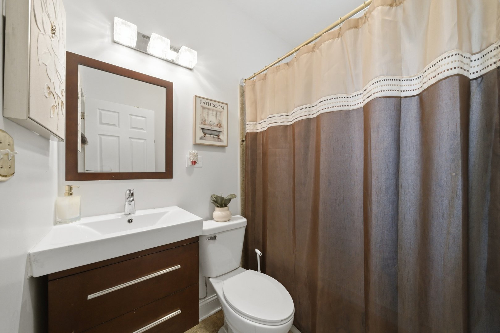 1253 South Tripp Avenue Chicago, IL 60623 - Photo 12 of 21 a bathroom with a sink a toilet a mirror and shower curtain