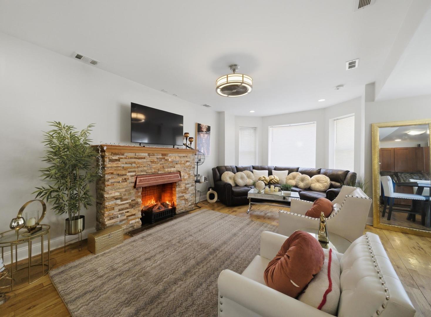 1253 South Tripp Avenue Chicago, IL 60623 - Photo 9 of 21 a living room with furniture a fireplace and a flat screen tv