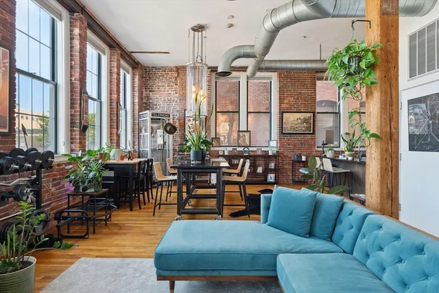 a living room with furniture potted plant and a large window