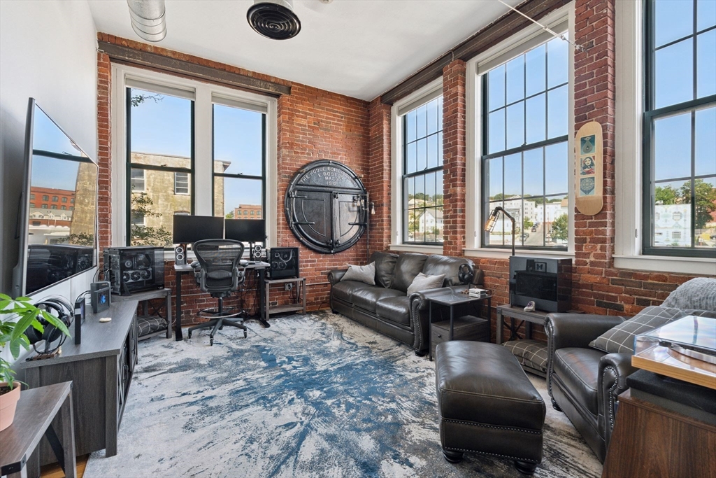 13-17 Willow Street, Unit 206 Lynn, MA 01901 - Photo 15 of 39 a living room with furniture a large window and wooden floor