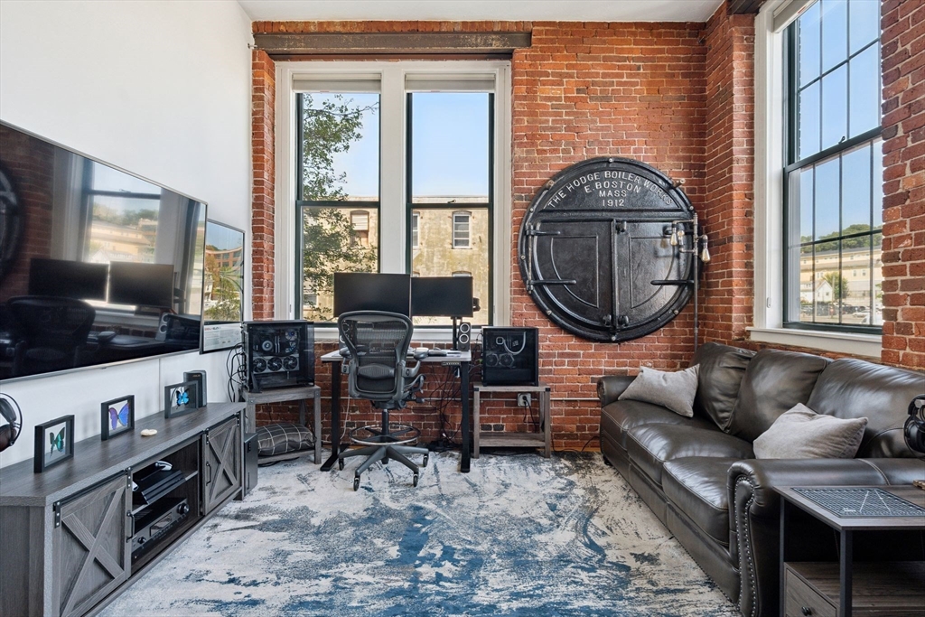 13-17 Willow Street, Unit 206 Lynn, MA 01901 - Photo 16 of 39 a living room with furniture a flat screen tv and a large window