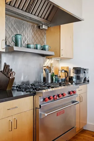 a kitchen with stove and cabinets