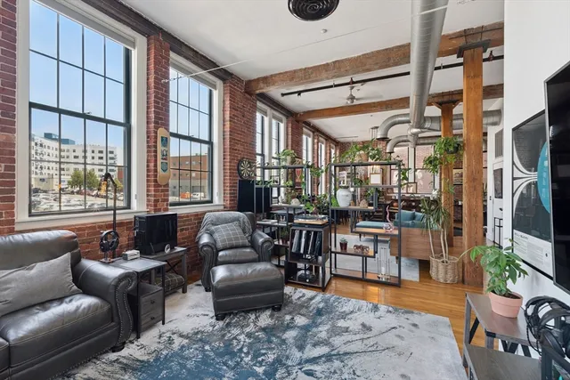 a living room with furniture a flat screen tv and a large window