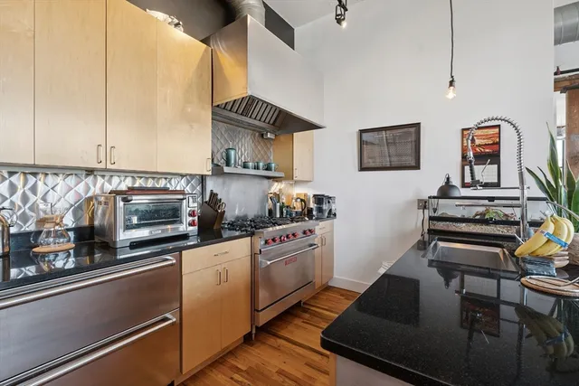a kitchen with stainless steel appliances a stove a sink and white cabinets