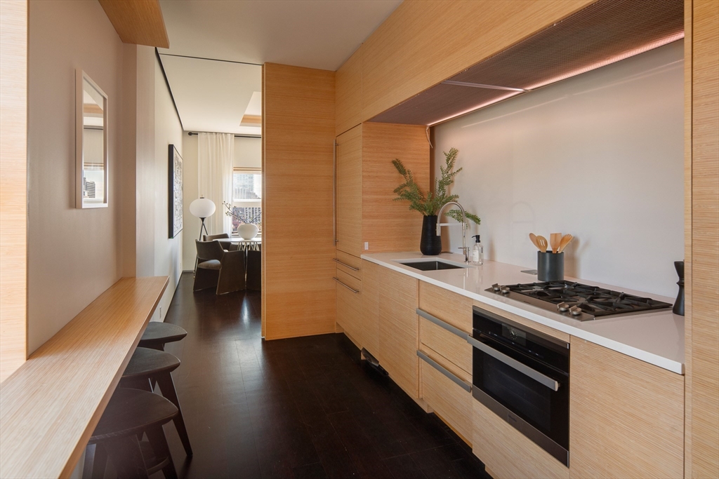 48 Beacon Street, Unit 12F Boston, MA 02108 - Photo 5 of 21 a kitchen with stainless steel appliances a stove a sink and wooden floor