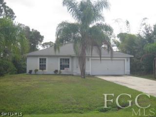 8136 Anhinga Road Fort Myers, FL 33967 - Photo 2 of 6 a view of a house with a yard and garage