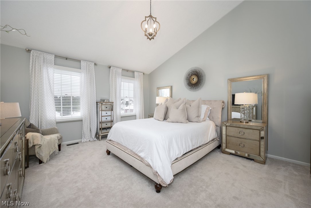3912 Raintree Circle Uniontown, OH 44685 - Photo 22 of 49 Primary bedroom featuring vaulted ceiling, carpet flooring, and hanging lights