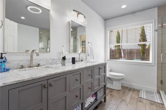 a bathroom with a double vanity sink toilet and shower