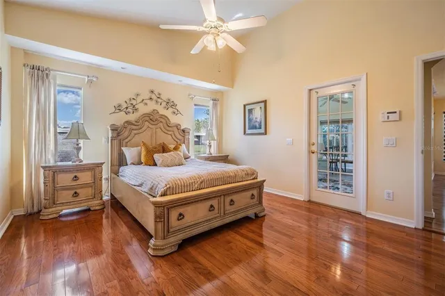 a bedroom with a large bed and a chandelier fan