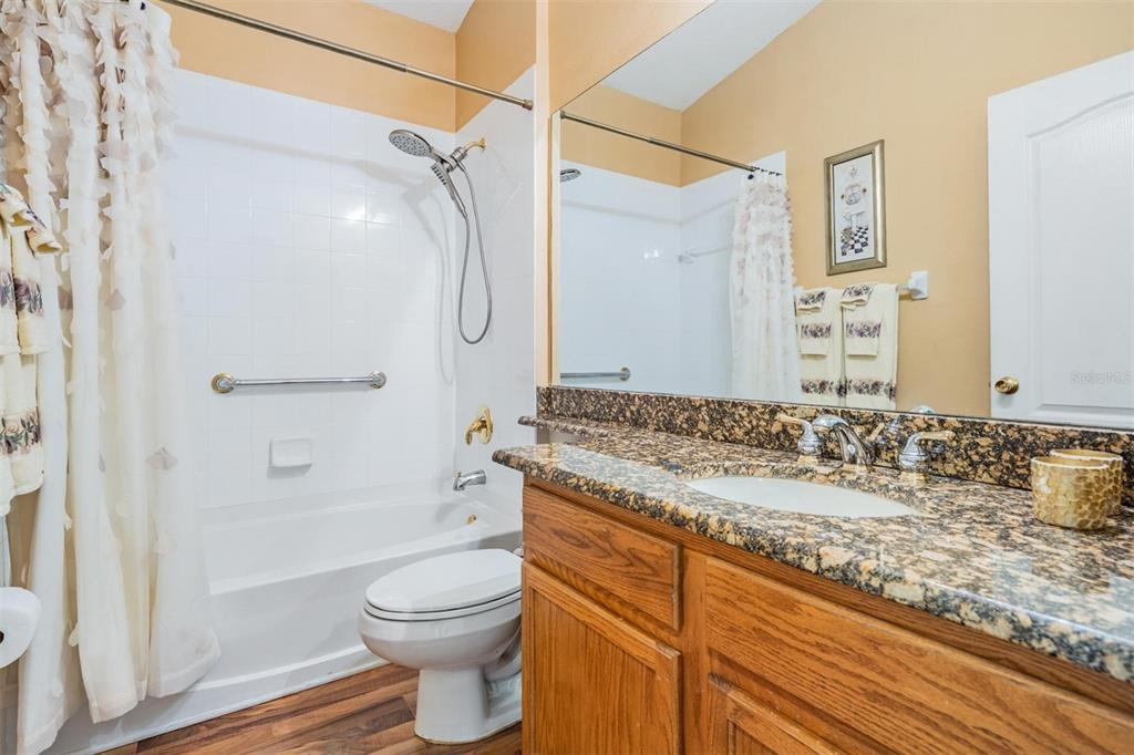 1042 Dustan Place Trinity, FL 34655 - Photo 18 of 48 a bathroom with a granite countertop sink toilet and shower