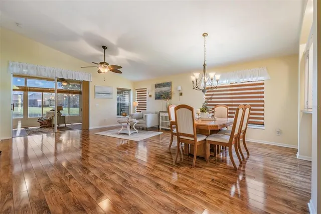 a dining room with furniture wooden floor a rug and a chandelier