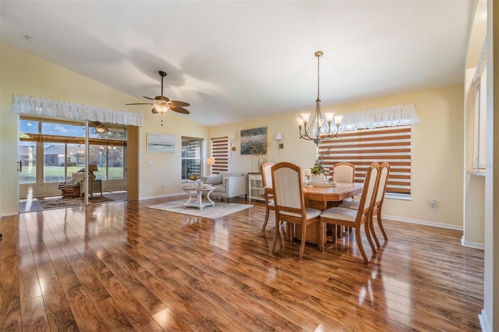 1042 Dustan Place Trinity, FL 34655 - Photo 5 of 48 a dining room with furniture wooden floor a rug and a chandelier