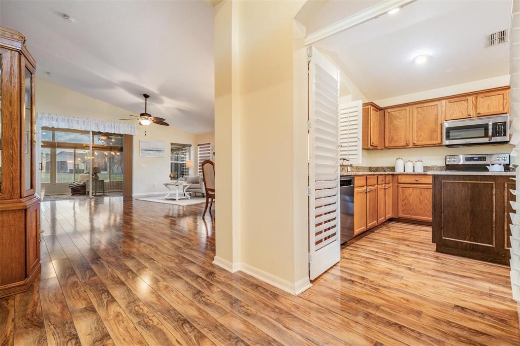 1042 Dustan Place Trinity, FL 34655 - Photo 7 of 48 a kitchen with stainless steel appliances granite countertop a stove top oven a sink dishwasher a refrigerator and white cabinets with wooden floor