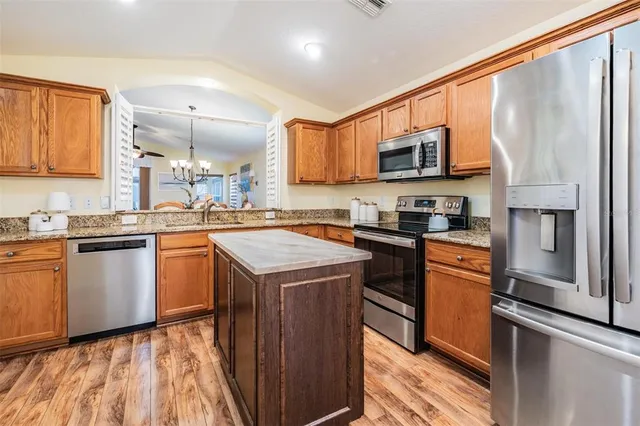 a kitchen with stainless steel appliances granite countertop a refrigerator a stove top oven a sink and dishwasher