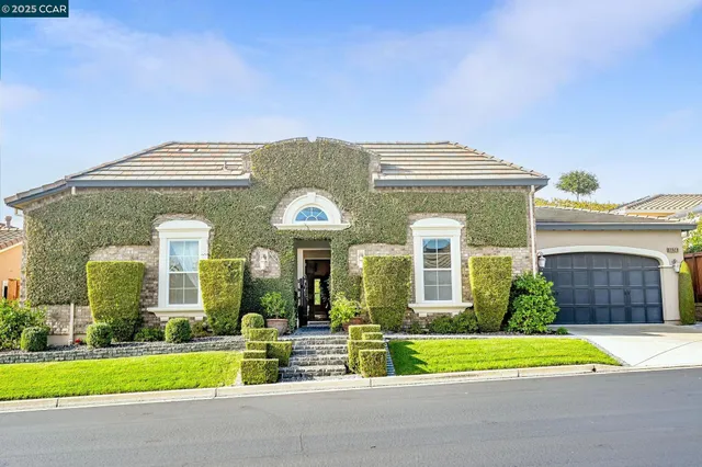 a front view of a house with a garden and plants