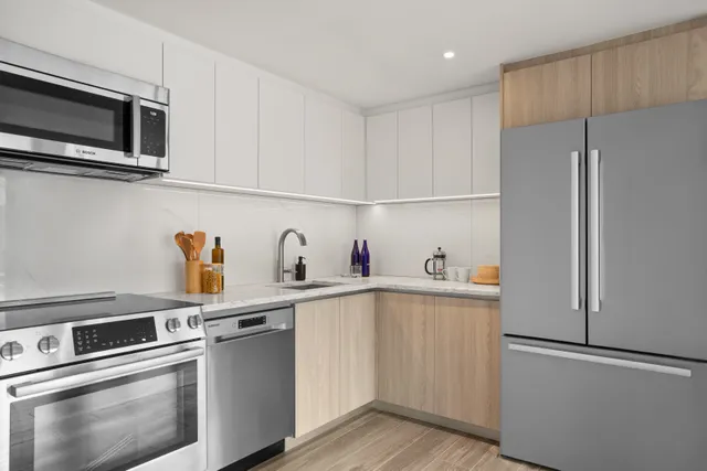 a kitchen with stainless steel appliances a refrigerator sink and microwave