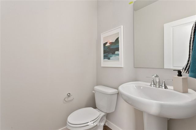 a bathroom with a granite countertop toilet a sink a mirror a bathtub and shower