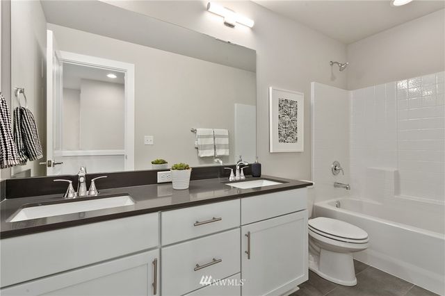 a front view of a house with garden and two chairs