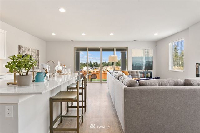 a kitchen with kitchen island white cabinets and stainless steel appliances