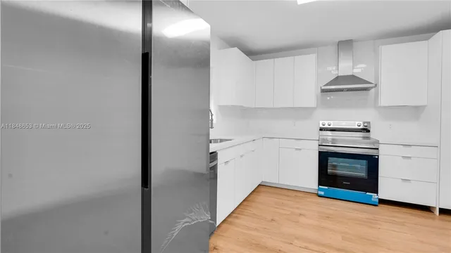 a kitchen with a refrigerator and a stove top oven