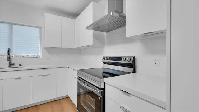 a kitchen with white cabinets and appliances