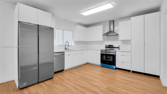 a kitchen with stainless steel appliances a refrigerator sink and cabinets
