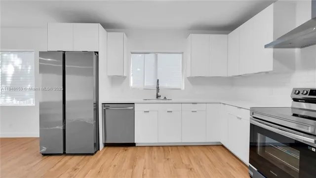a kitchen with a refrigerator sink and cabinets