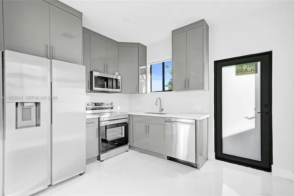 a utility room with sink dryer and washer