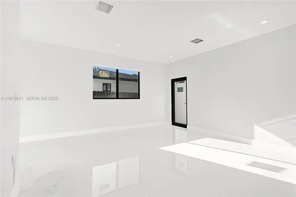 an empty room with a window and a ceiling fan