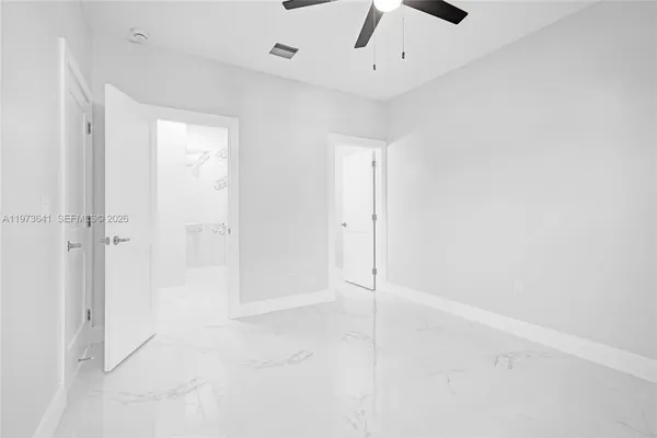 an empty room with a ceiling fan and carpet