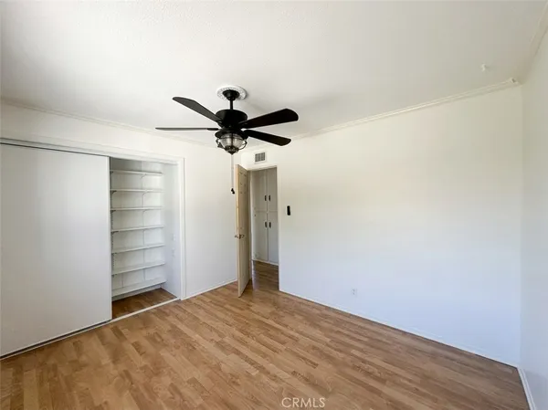 a view of a room with a ceiling fan and wooden floor