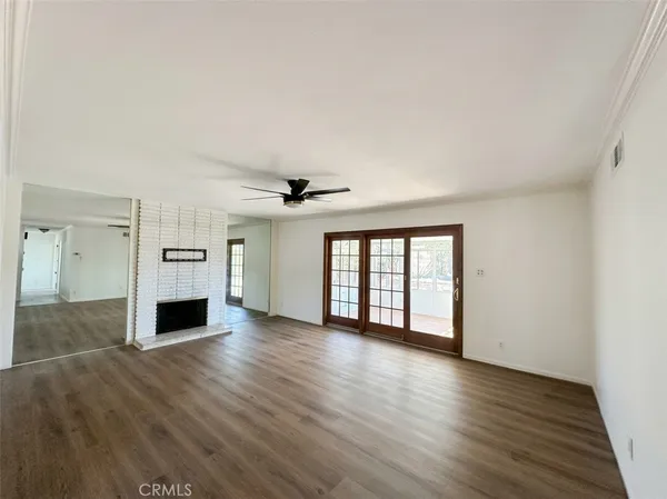 an empty room with windows fireplace and windows