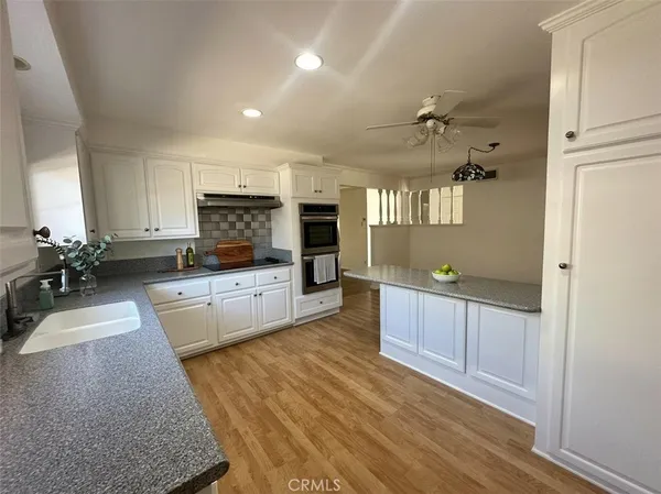 a large living room with stainless steel appliances granite countertop furniture a fireplace and a window